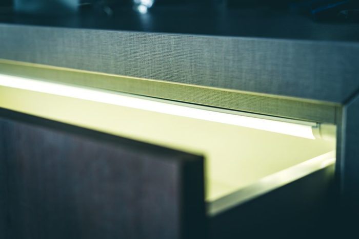 Diese Detailansicht der leicht geöffneten obersten Schublade der Kommode „Paris“ zeigt die an der Oberkante angebrachte LED Lichtleiste.